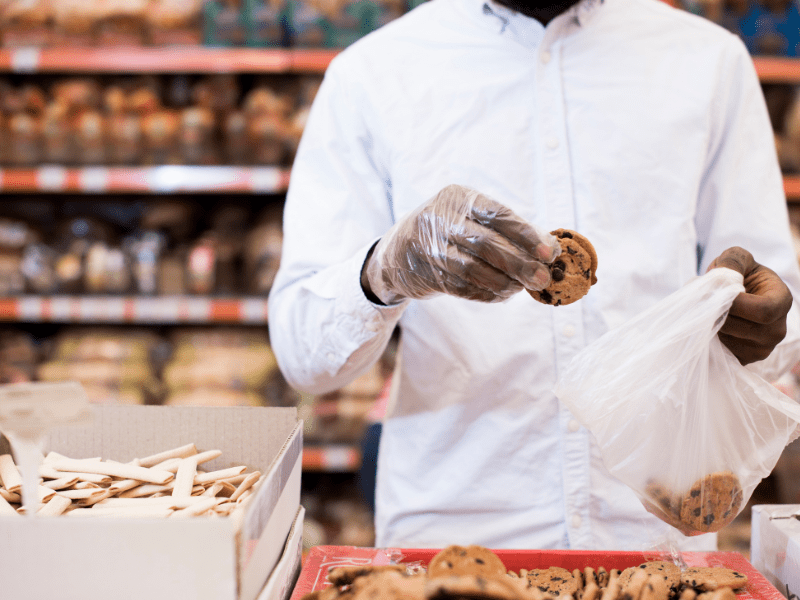 Homem preto, dono de uma franquia de alimentação, segurando um cookie